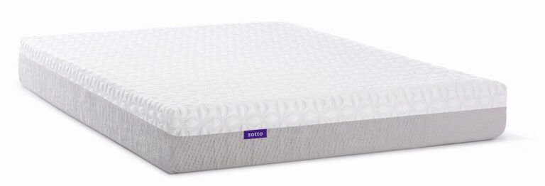 A rectangular mattress with a white, textured top layer and a light gray lower portion. The surface pattern on the top layer is formed by an arrangement of raised geometric shapes. There is a small purple tag on the side indicating the Zotto brand name.