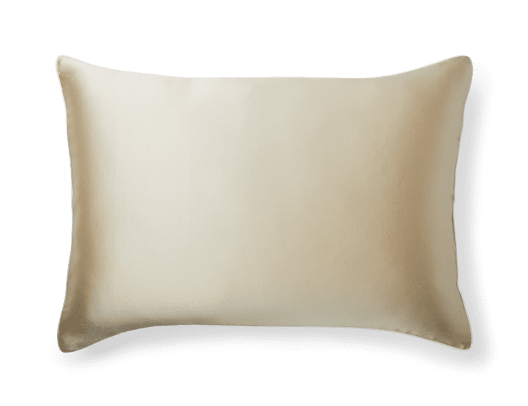 The Silk Pillowcase is a rectangular, beige pillow with a smooth and shiny fabric surface. It boasts a well-defined shape, and the material appears soft and luxurious, casting a faint shadow on the bottom and right sides against a white background.