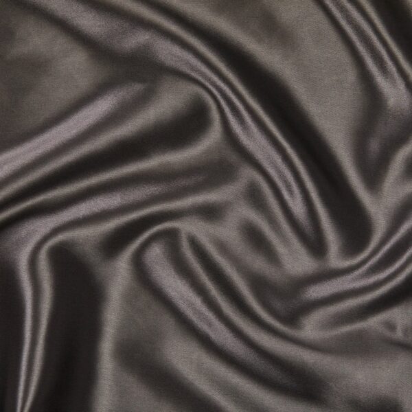 A close-up of the Silk Pillowcase, showcasing its smooth, dark-colored satin fabric with gentle folds and a soft sheen, highlighting its luxurious texture and elegant appearance.