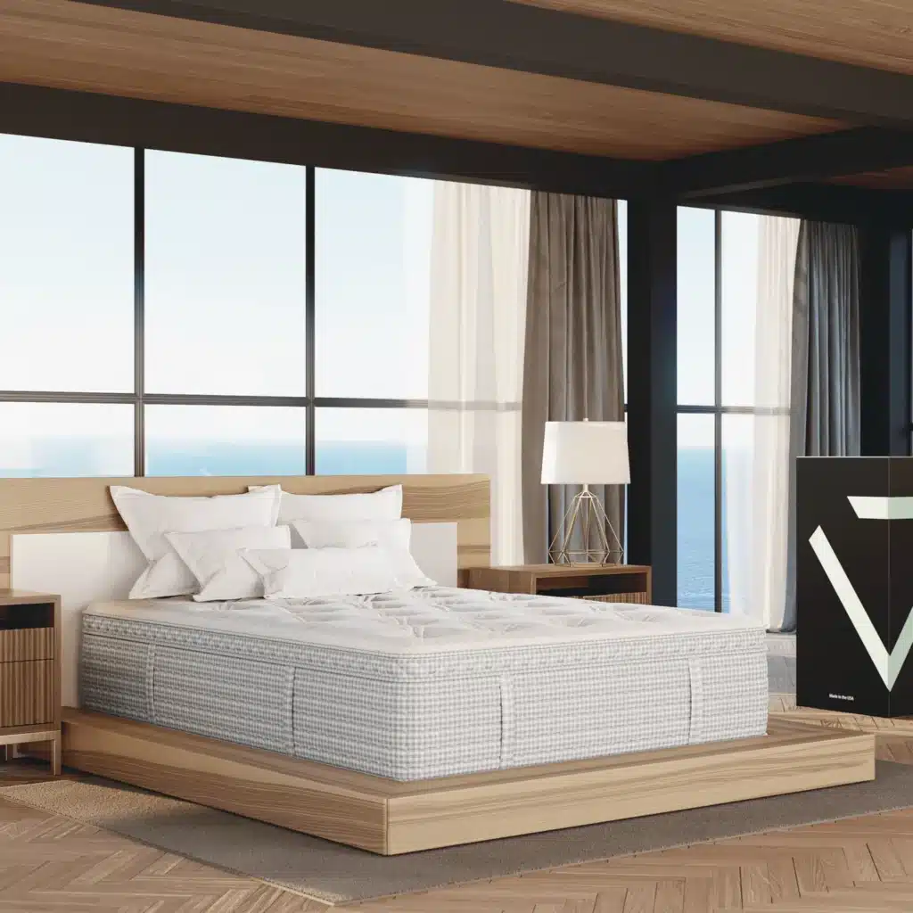 A modern bedroom features a large bed with a light wood frame and white bedding. The room has floor-to-ceiling windows offering an ocean view. A bedside table with a lamp is next to the bed, and a dark-colored cabinet with a geometric design is in the corner.