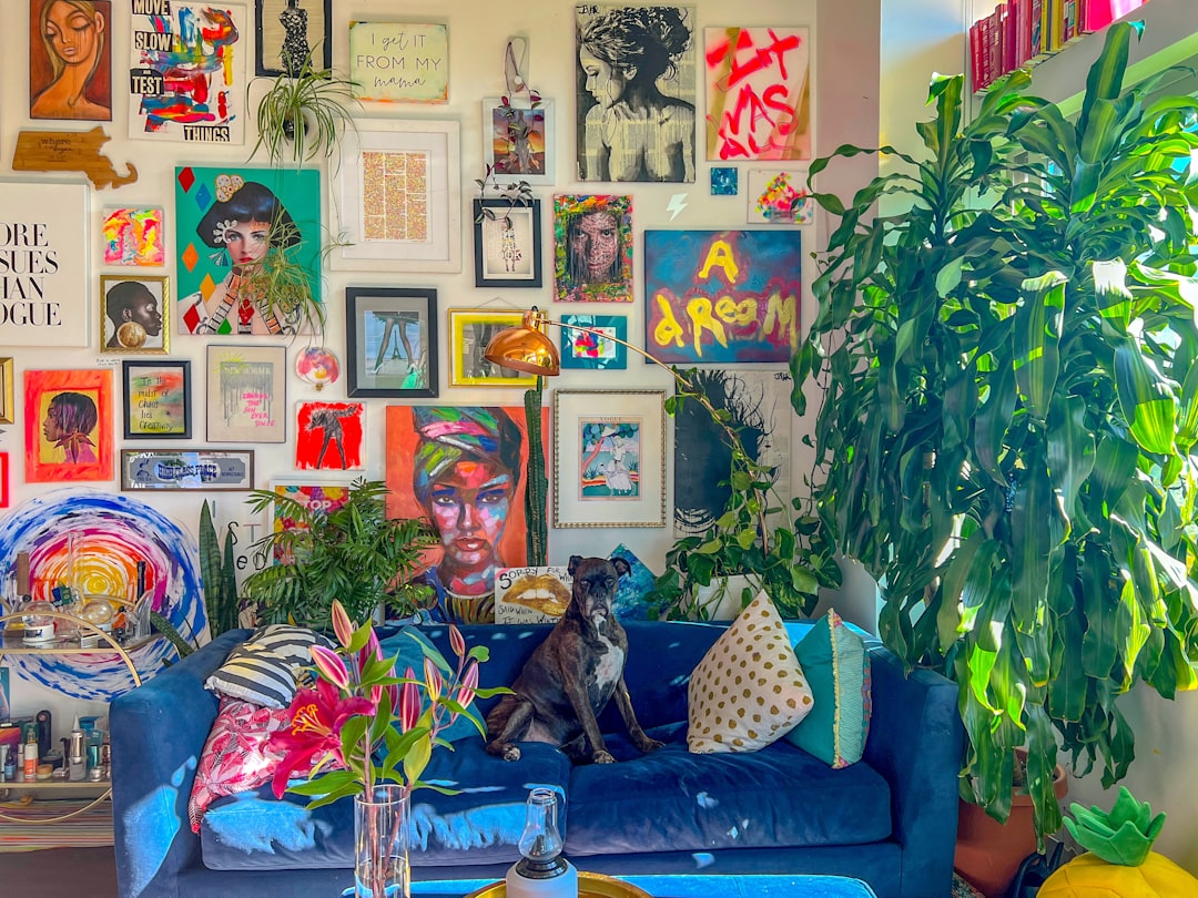 a dog sitting on a couch in a room with art on the wall