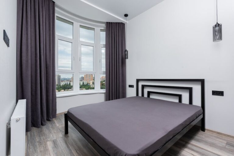 a bed in a room with a window and city view