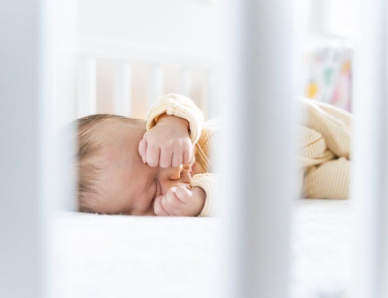 a baby lying on a bed