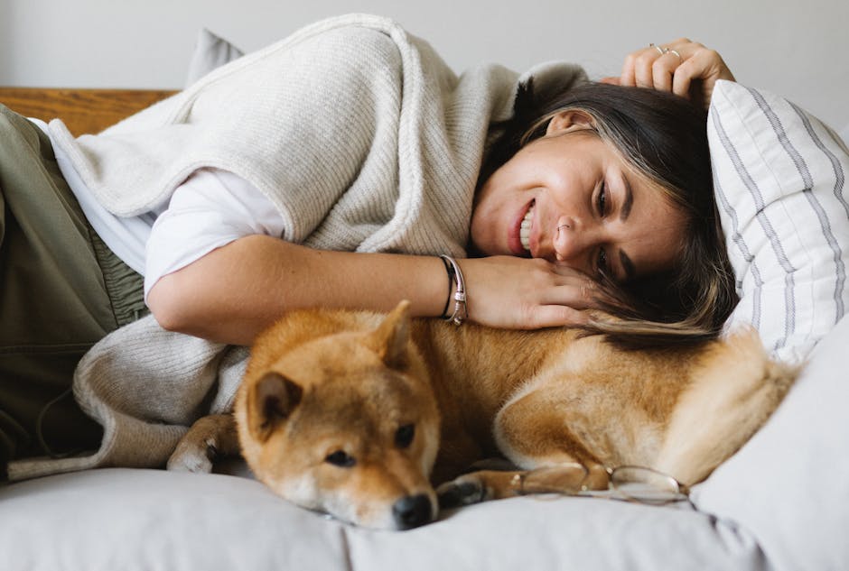 a woman lying on a bed with a dog