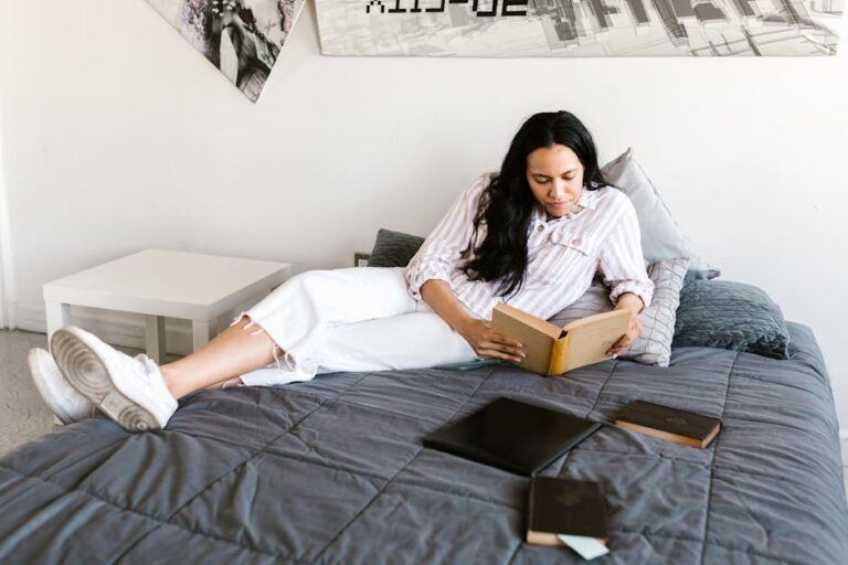 a woman sitting on a bed reading a book