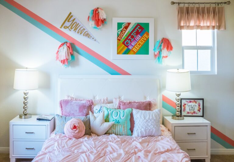 a bedroom with pink bedding and pillows