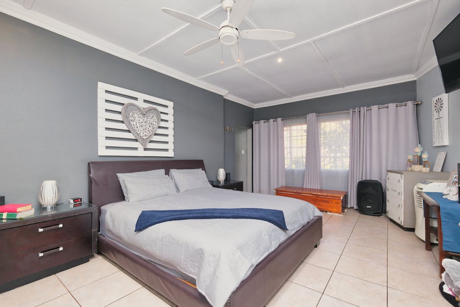 a bedroom with a white ceiling fan and a bed