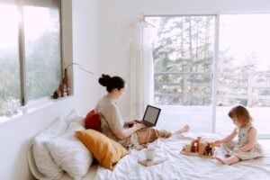 a woman sitting on a bed with a laptop