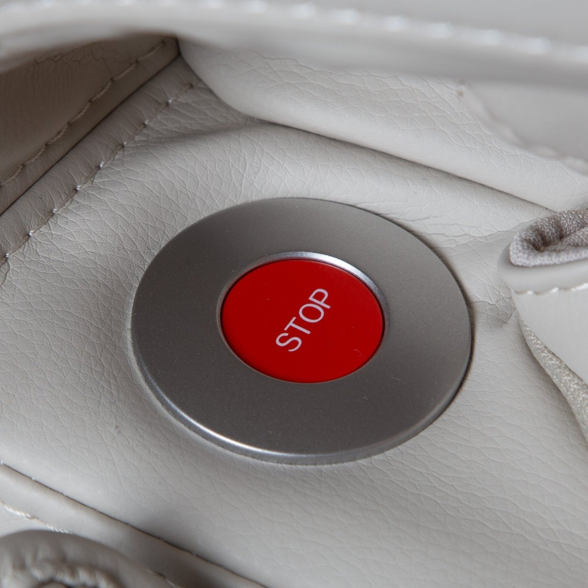 Close up of a red stop button on the Osaki Helix LE taupe massage chair