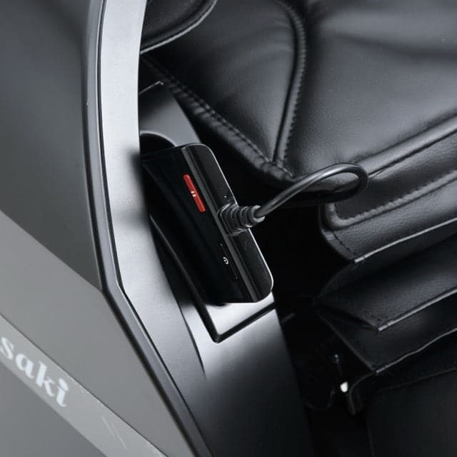 A solo flex remote holder with a black remote plugged into a black massage chair