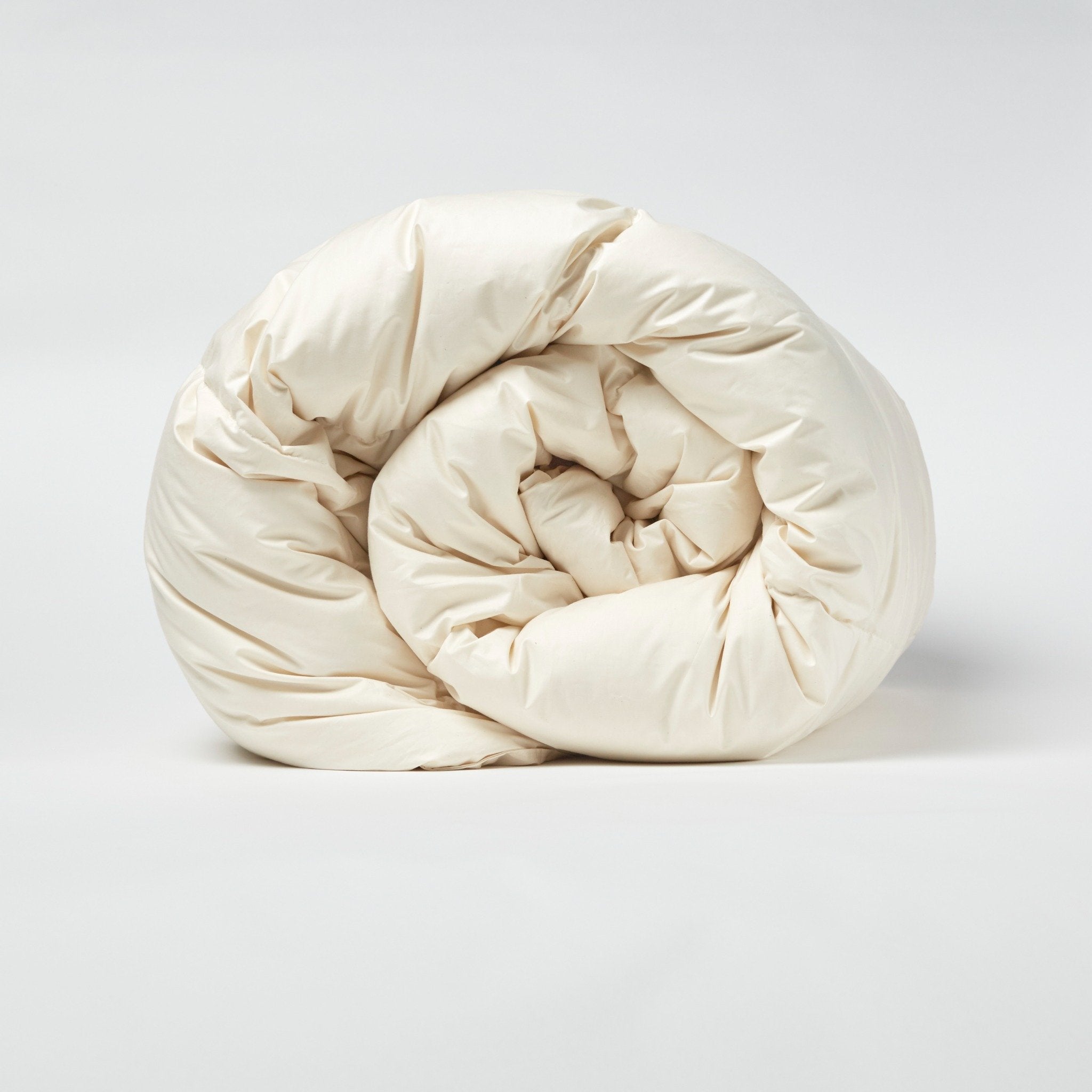 Rolled cream LanaDown duvet or comforter with a textured surface on a white background
