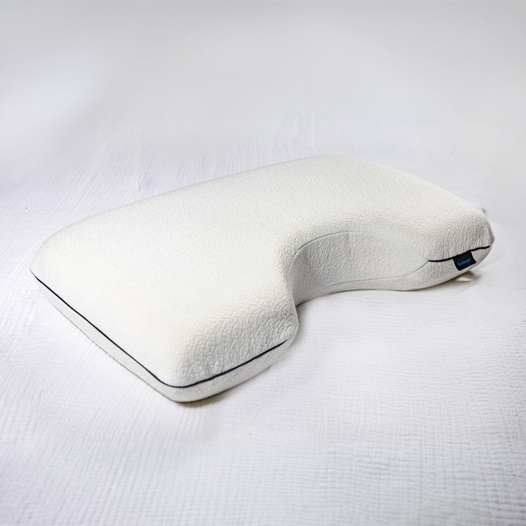 White textured Technogel Side sleeper pillow with dark piping on a white sheet