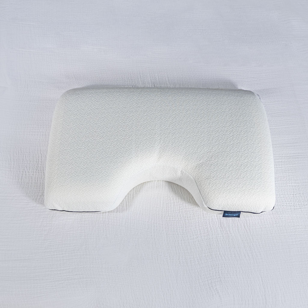 White Technogel SideSleeperPillow with a U-shaped cutout on a white textured sheet