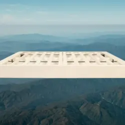 Light beige wood foundation box spring with black slats floating above mountain range