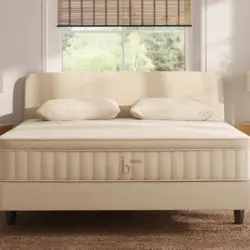 Luxe natural mattress on a beige foundation with an upholstered headboard and pillows