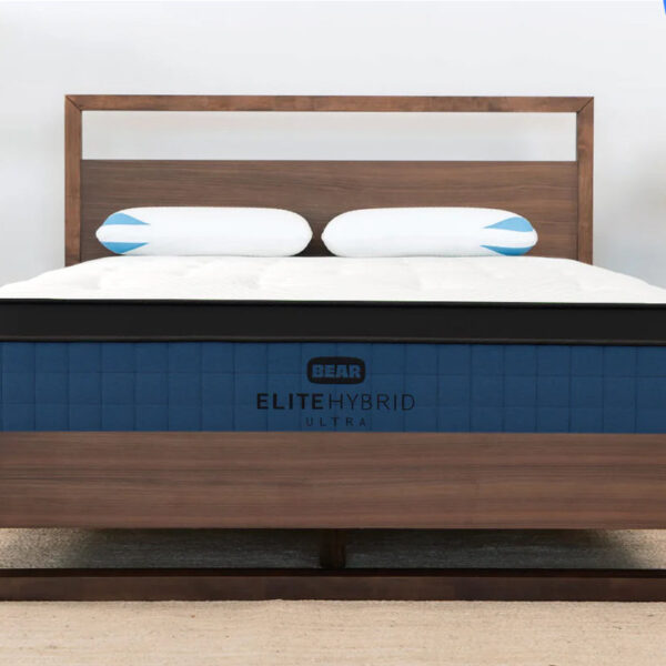 EliteUltraHybrid Enviro mattress in a wooden bed frame, with two pillows against the headboard.