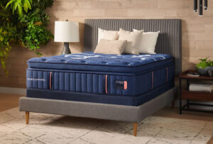 Stearns & Foster Lux Estate mattress with navy patterned quilted top and Lux Estate label on a bedroom platform