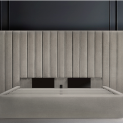 Light gray Milan bed with a tall fluted velvet headboard against dark paneling