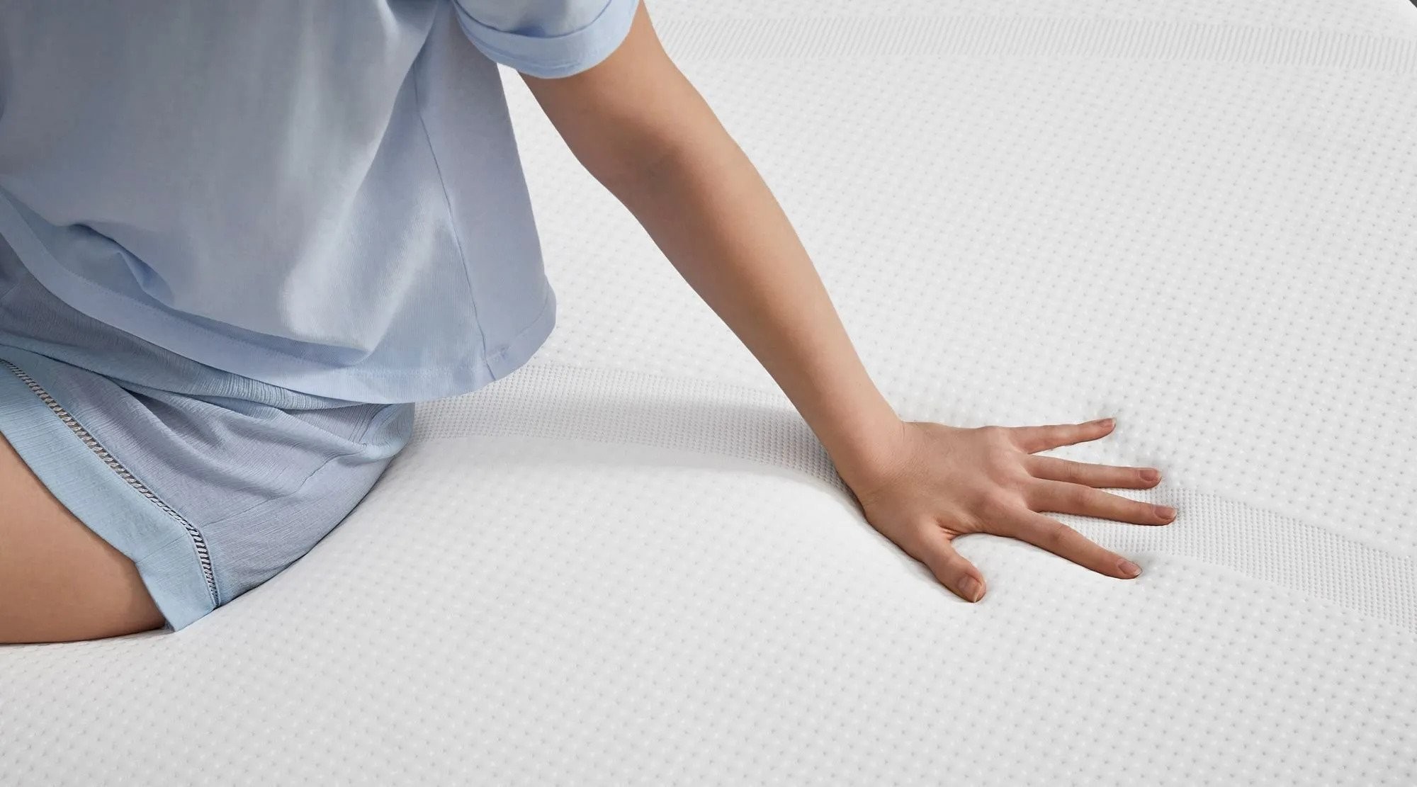 A hand pressing into the TEMPUR-Cloud mattress surface