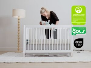 Leesa Natural Crib Mattress in a white crib with GREENGUARD Gold, GOLS and OEKO-TEX certification badges