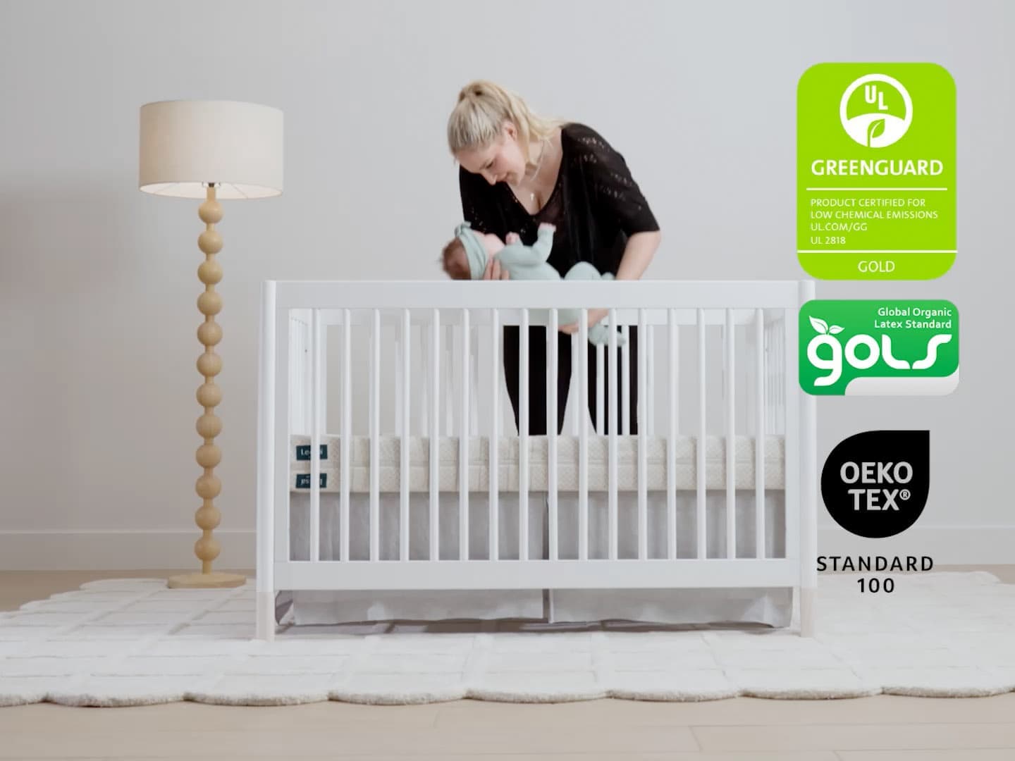 Leesa Natural Crib Mattress in a white crib with GREENGUARD Gold, GOLS and OEKO-TEX certification badges