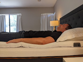 Yawnder testing the Perfectly Snug Smart Topper while lying on the back
