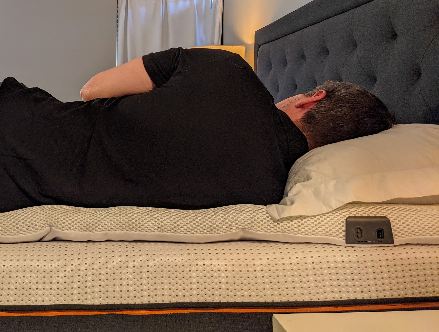Yawnder testing the Perfectly Snug Smart Topper while lying on the side