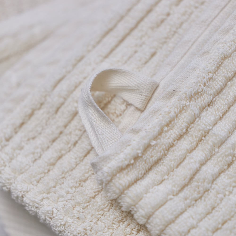 Close-up of an Avocado organic cotton towel showing the ribbed terry fabric and hanging loop