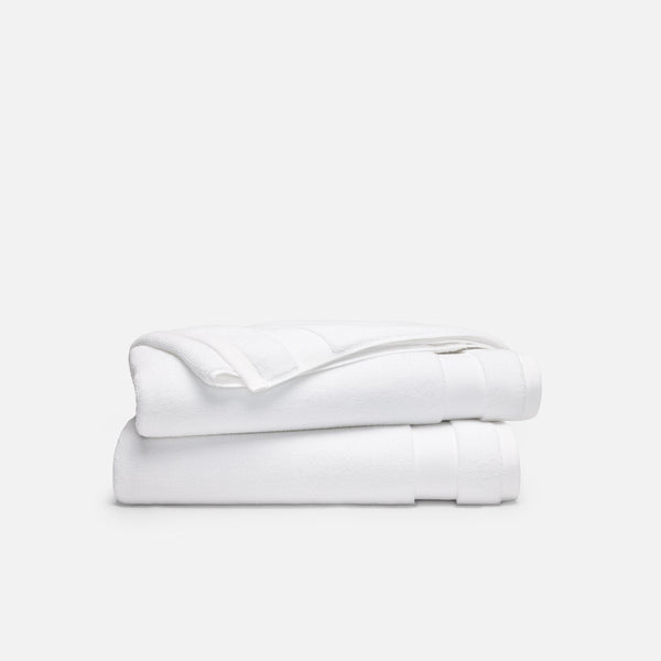 Two white Brooklinen Super-Plush bath towels folded in a stack
