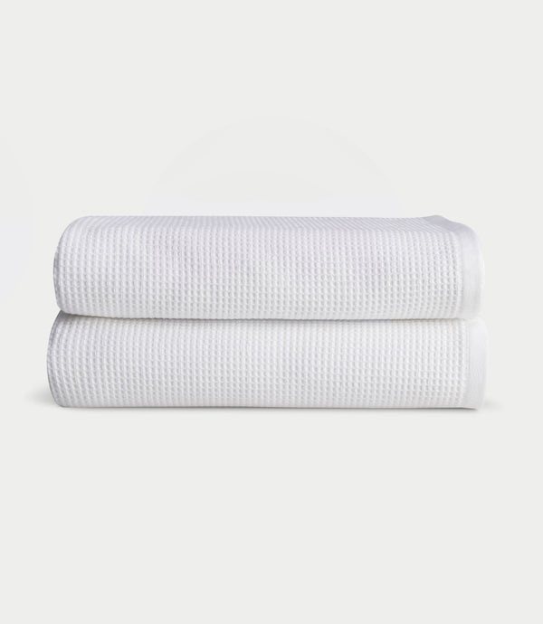 Two white Cozy Earth Waffle bath towels folded in a stack