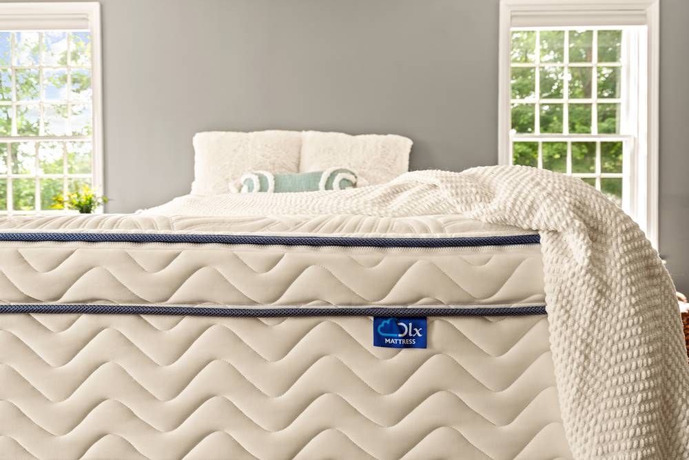 Official close-up photograph of DLX Premier Hybrid mattress label and stitched sidewall