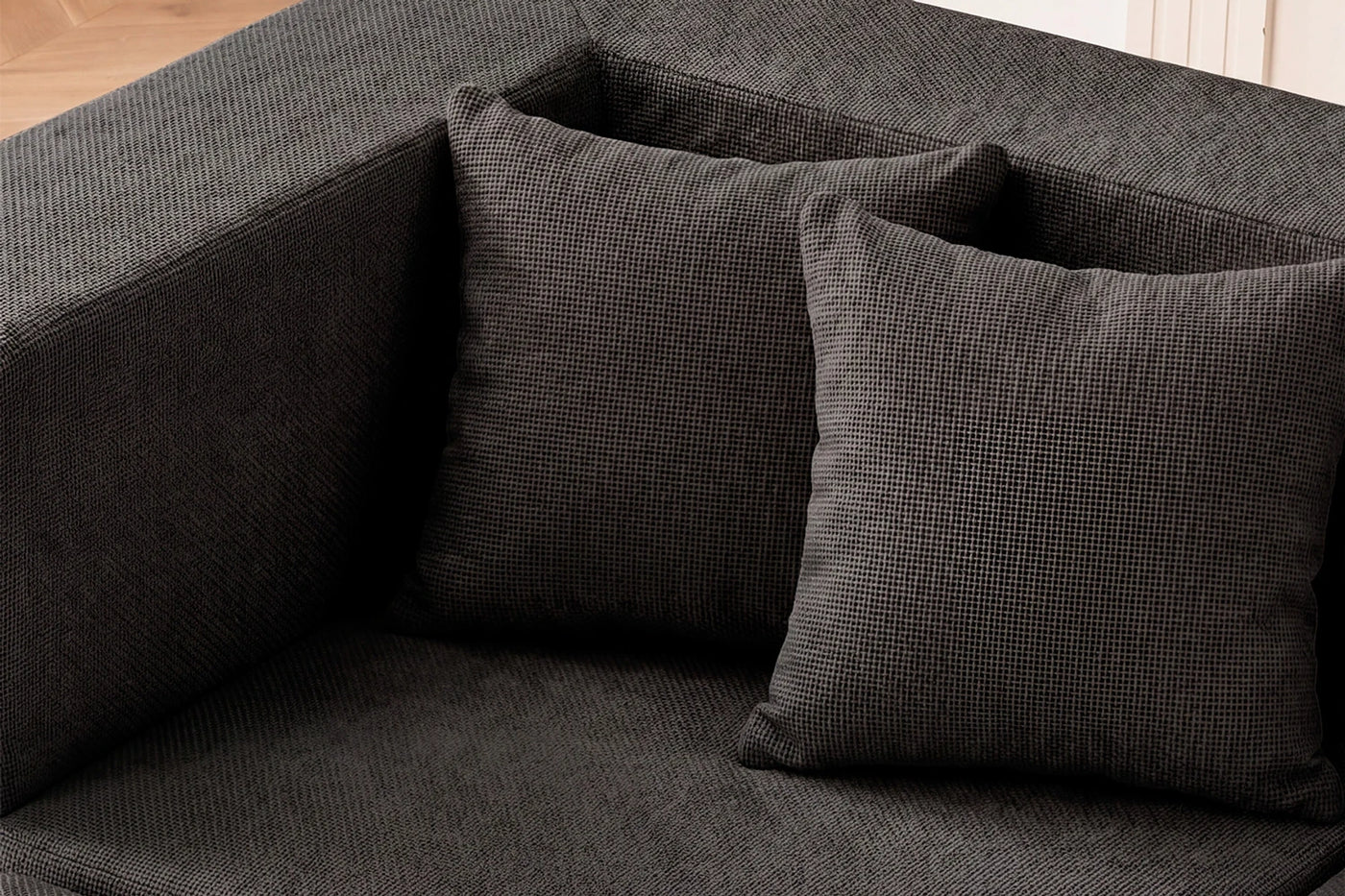 Close view of the dark grey chenille upholstery and back cushions on a Monvane sofa